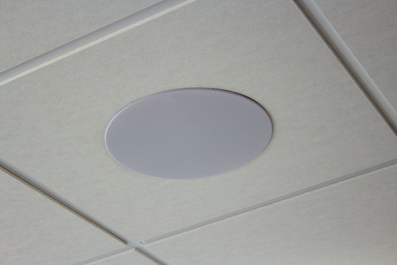 Bündig in die Rasterdecke eingebauter runder Deckenlautsprecher