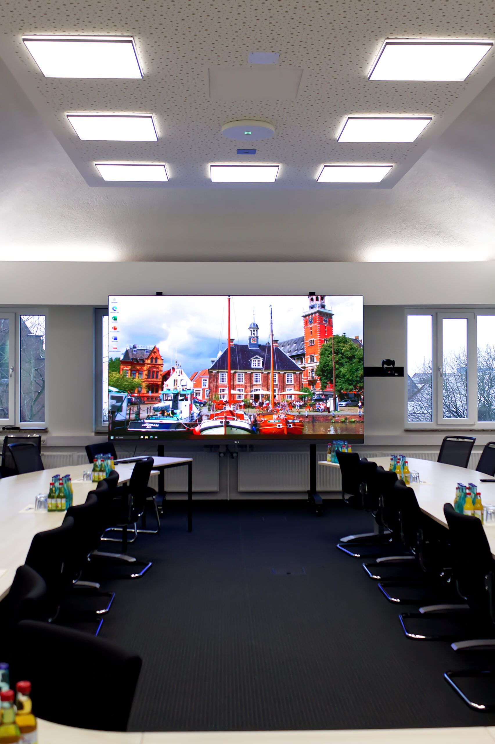Sitzungssaal der Stadt Leer mit Deckenmikrofonen über dem Sitzungstisch und LED-Wall im Hintergrund