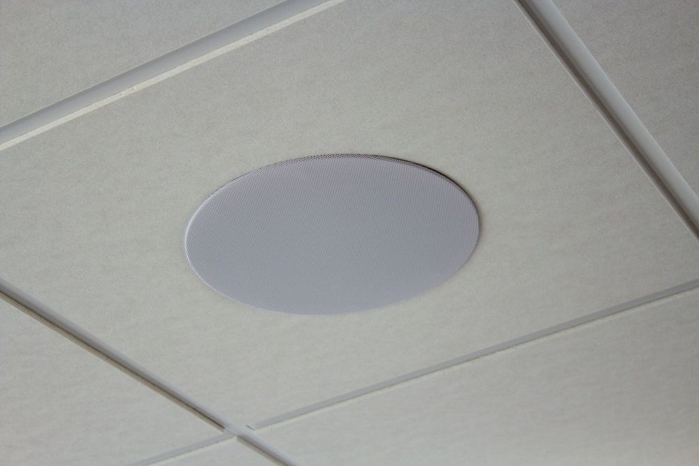 Bündig in die Rasterdecke eingebauter runder Deckenlautsprecher